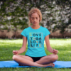 Junge Frau beim Yoga im Park mit unserem Love Yoga Love Life Shirt in Karibikblau